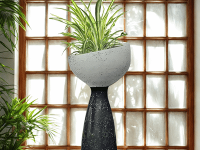 Handmade concrete terrazzo planter with pedestal base, styled indoors with spider plant