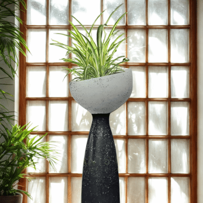 Handmade concrete terrazzo planter with pedestal base, styled indoors with spider plant